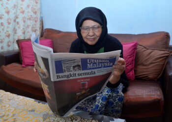 HALIMAH Mat Aris, 74, membaca Utusan Malaysia ketika ditemui di Silibin, Ipoh hari ini. - UTUSAN/ZULFACHRI ZULKI