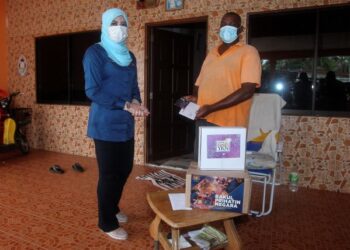 RINA Mohd. Harun (kiri) menyampaikan sumbangan kepada penerima Selvaraju Kanniappen pada Majlis Penyampaian Sumbangan dan Bakul Prihatin Negara di Taman Teluk Merbau, Sungai Pelek, Sepang, Selangor. - FOTO/FAISOL MUSTAFA