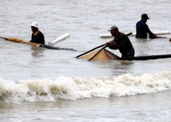 AMIR Hamzah Mohd. Zain, 52, (tengah) bersama rakannya Ramli Ibrahim, 48, (kiri) dan Mazlan Mahamod, 37, mencari rezeki dengan menyungkur udang geragau dalam keadaan ombak kuat di Pantai Puteri, Tanjung Kling. -UTUSAN/ RASUL AZLI SAMAD