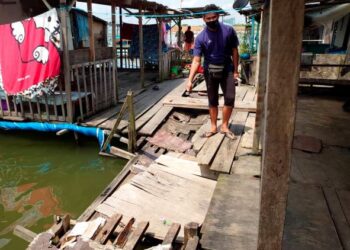 AWIE Mee menunjukkan titi kayu yang sudah usang dan berbahaya digunakan penduduk di perkampungan Orang Asli Kampung Teluk Jawa, Pasir Gudang, Johor. – UTUSAN/KHAIRUL MOHD ALI