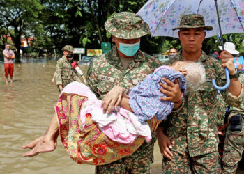 ANGGOTA ATM mengangkat warga emas berumur 92, Che Wan Harun yang beberapa hari terkandas di kediamannya di Taman Sri Muda, Shah Alam, semalam. UTUSAN/ZULFADHLI ZAKI