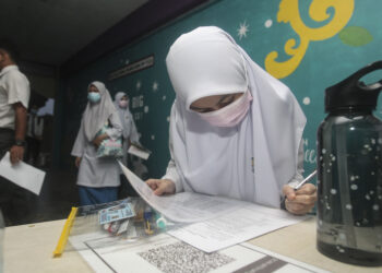 CALON SPM menyemak senarai nama sebelum memasuki dewan peperiksaan pada hari pertama peperiksaan ketika tinjauan di sekitar sekolah Putrajaya, hari ini. - UTUSAN/FAISOL MUSTAFA