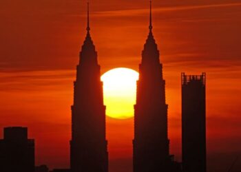 KELIHATAN matahari terbenam berada di tengah-tengah Menara Berkembar Kuala Lumpur. Gambar ini dirakam pada pukul 7 malam di Bukit Ampang, Selangor, semalam. - UTUSAN/ASWAD YAHYA