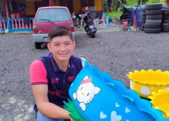 HASLIZAN Hasrin menunjukkan pasu bunga daripada tayar terpakai yang siap digubah di rumahnya di Kampung Parit Haji Rashid, Tanjung Air Hitam, di Pontian, Johor.