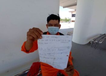 MOHAMAD Azizi Bahuddin menunjukkan nota bahasa asing dicatatnya yang masih disimpan bagi memudahkan dia berinteraksi dengan pelancong di sekitar Bandar Mersing di Johor. -UTUSAN/MASTURAH SURADI