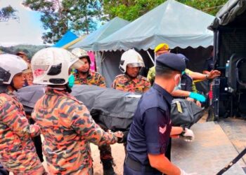 ANGGOTA bomba mengusung mayat seorang lelaki dewasa yang ditemukan dalam operasi mencari dan menyelamat di Father’s Organics Farm, Batang Kali, pagi semalam. – IHSAN NADMA
