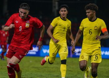 AKSI Ubaidillah Shamsul Fazili (jersi No. 3) ketika membantu Malaysia menentang Laos dalam aksi pembukaan Sukan SEA di Phnom Penh, Kemboja malam tadi. - UTUSAN/AMIr KHALID