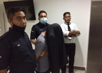 MUHAMAD Hafidz Azrul Mat Nizan (dua, kiri) yang dituduh membuat ugutan bunuh terhadap pegawai dan anggota polis dibawa keluar dari Mahkamah Sesyen Kuala Terengganu, hari ini. - UTUSAN/TENGKU DANISH BAHRI TENGKU YUSOFF