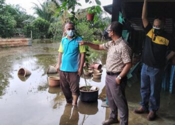 NOOR Azmi Ghazali (tengah) melawat rumah penduduk yang dilanda banjir di Kampung Tanjung Bugis,  Padang Lalang di Semanggol hari ini. - UTUSAN/WAT KAMAL ABAS