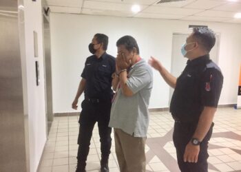 WAN Azhar Wan Ismail (tengah) yang dituduh memiliki video lucah kanak-kanak di dalam komputer riba miliknya dibawa ke Mahkamah Majistret Kuala Terengganu di Kuala Terengganu, hari ini.