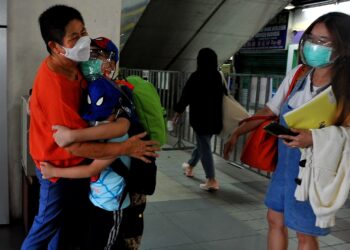 LEE Siew Kean (kiri) memeluk erat dua cucunya yang pulang ke tanah air bersama ibu mereka, Tai Chin Lin di bawah skim VTL darat melalui perkhidmatan bas di Terminal Larkin Sentral, Johor Bahru. - UTUSAN/RAJA JAAFAR ALI