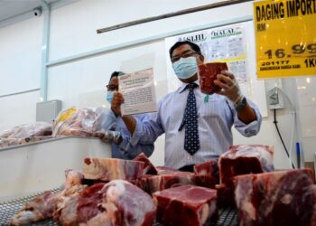 Mas Imran Adam menunjukkan notis berkenaan jualan daging halal yang diimport di Pasaraya Econsave Taman Teratai di sini, hari ini.