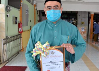 MOHD. Nasrizal Abdul Aziz menunjukkan sijil penghargaan sebagai Tokoh Maulidur Rasul Daerah Kampar bapanya, Allahyarham Tan Sri Abdul Aziz Shamsuddin di Masjid An-Nur di Kampar hari ini. - GAMBAR: ZULFACHRI ZULKIFLI