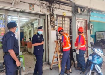 Kakitangan TNB memotong elektrik di sebuah premis judi haram di Manjung semalam. - GAMBAR IHSAN PDRM