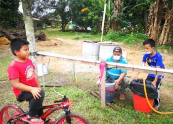 Seorang penduduk dan anaknya mengambil air di Telaga Rakyat Anak Jati Jalan Kebun, Shah Alam  hari ini.