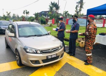 AZMAN Alias (kiri) mengagihkan pek lemang dan rendang kepada penduduk di Bandar Al-Muktaffi Billah Shah (AMBS), Dungun semalam.