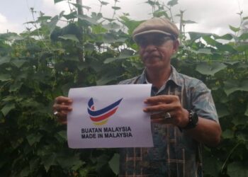 Rosol Wahid memegang logo Buatan Malaysia selepas mengadakan lawatan di Projek Fertigasi Tanaman Timun yang diusahakan Majlis Belia Hulu Terengganu di Kampung Sungai Ular, Hulu Terengganu, hari ini.