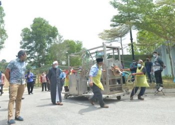 Khairy Jamaluddin (kiri) dan Dr. Zulkifli Mohamad al-Bakri menyaksikan demonstrasi penggunaan sangkar penyembelihan mudah alih di ibu negara baru-baru ini.