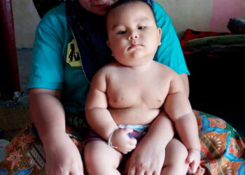 MUHAMMAD Wabil Nuh Mohd. Luthfi di pangkuan ibunya, Rosniza Yusop di rumah mereka di Kampung Weng Dalam, Baling.
