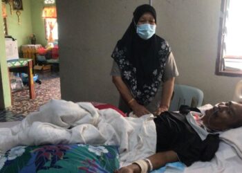 HASANAH Mahamud Yusoff bersama anaknya, Mohd. Hamidi Khairudeen yang terlantar sakit selepas pembedahan kepala di rumah Felda Kota Gelanggi Dua, Jerantut, Pahang. - FOTO/HARIS FADILAH AHMAD