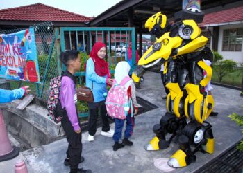 MASKOT Bumblebee menyambut murid-murid pada hari pertama persekolahan SK Meru Raya di Ipoh, semalam. – UTUSAN/MUHAMAD NAZREEN SYAH MUSTHAFA