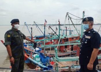Muhammad Abdul Halim (depan) menunjukkan bot nelayan  seludup PATI yang dirampas dalam Op Benteng.