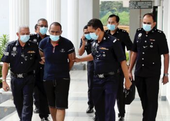 ANGGOTA polis mengiringi tertuduh, A.S Sitambarasan (tengah) yang berdepan tuduhan membunuh ketika di bawa ke Mahkamah Majistret di Alor Gajah, hari ini.. UTUSAN/ RASUL AZLI SAMAD