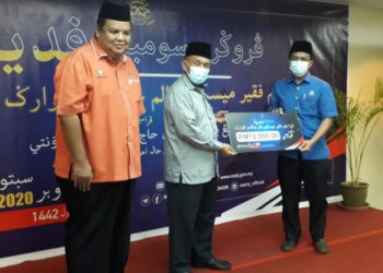 TOSRIN Jarvanthi (tengah) menyerahkan sumbangan kepada Jabatan Agama Islam Batu Pahat dalam majlis sumbangan fidyah kepada anak-anak yatim dan miskin dalam jagaan keluarga Johor di Kulai.