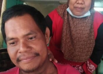 ZARINA Talib menunjukkan parut kesan lecur di leher suaminya, Mohd Taha selepas menerima rawatan radioterapi.-UTUSAN/FARAHWAHIDA AHMAD