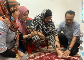 Aida Agil (dua dari kanan) menunjukkan masalah penyakit dialami ketika ditemui di rumahnya di Jalan Sri Stulang, Johor Bahru semalam.