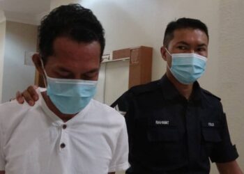 ROSAIDI Ismail, 47, diiringi anggota polis ketika dibawa keluar dari Mahkamah Sesyen di sini sejurus tidak mengaku salah tiga tuduhan pecah amanah. -UTUSAN/MOHD SHAHRULANOOR ISHAK