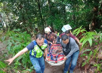 ANGGOTA membawa mayat seorang remaja yang maut selepas tergelincir ketika mendaki Bukit Banang, Batu Pahat.-Gambar Bomba Johor