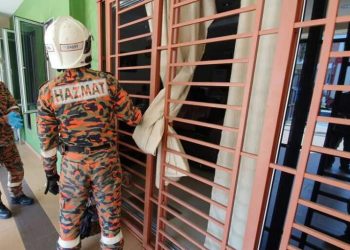ANGGOTA bomba membuka kunci pintu rumah bagi mengeluarkan warga emas yang ditemukan meninggal dunia seorang diri di rumahnya di Taman Pelangi. -Gambar Bomba Johor