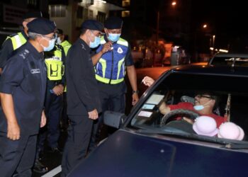 ABDUL Majid Mohd. Ali (dua dari kanan) memeriksa pengenalan diri pengguna jalan raya dalam sekatan jalan raya di persimpangan Kampung Portugis, Ujong Pasir, Melaka. UTUSAN/ RASUL AZLI SAMAD