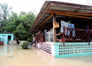 PENDUDUK mengalihkan perabot dan kelengkapan rumah ke tempat tinggi berikutan air memasuki rumah akibat banjir di Kampung Parit Penghulu Benteng, Sungai Rambai di Jasin, Melaka. UTUSAN/ RASUL AZLI SAMAD
