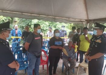 YAHAYA Othman (kanan) menyampaikan watikah ucapan takziah kepada balu mendiang Koperal Baharuddin, Relow Along Ko dalam satu majlis di Kampung Orang Asli Sungai Sampo, Ayer Hitam, Bandar Seri Jempol, Jempol petang tadi.-Gambar Ihsan PDRM.