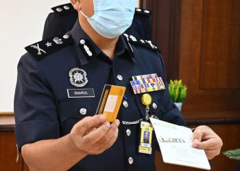 SHAHRUL Lalli Masduki (tengah) menunjukkan kad bank milik peminjam yang turut dirampas dalam serbuan di Taman Cheng Perdana pada sidang akhbar di IPK Melaka. UTUSAN/ RASUL AZLI SAMAD