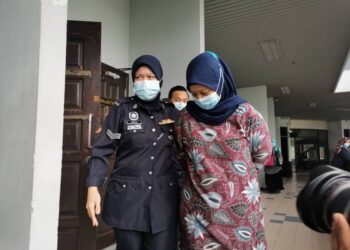 TERTUDUH, Syabariyah Samsuri diiringi anggota polis selepas didenda RM1,500 kerana menyembunyikan kelahiran dalam pendakwaan di Mahkamah Majistret di Ayer Keroh, Melaka. UTUSAN/ DIYANATUL ATIQAH ZAKARYA