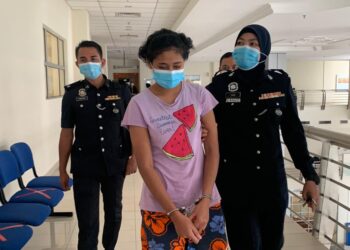 MERIYANA (tengah) diiringi polis ketika di bawa ke Mahkamah Klang, Selangor hari ini atas dakwaan mencederakan anak majikannya di sebuah rumah di Taman Mewah 3 Disember lalu.