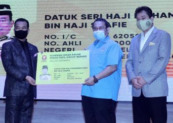 ABDUL Fattah Abdullah (tengah) menyerahkan kad keahlian koperasi kepada Mohamad Fazil Shafie (kiri) sambil disaksikan Tengku Hishammuddin Zaizi Tengku Azman Shah Alhaj selepas merasmikan pelancaran Koperasi Kopirnafg di Hotel Ames, Melaka. -  UTUSAN/RASUL AZLI SAMAD
