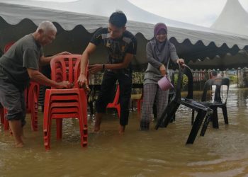 MOHD. IDRIS Che Alas (kiri) dibantu anak dan menantunya membersihkan kerusi untuk tetamu bagi majlis menyambut menantu yang dijadual diadakan esok di Kampung Pengkalan Ajal, Hulu Terengganu.-UTUSAN/Noor Hayati Mamat