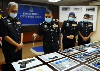 AYOB Khan Mydin Pitchay (dua kiri) menunjukkan gambar pistol separa automatik hasil penemuan senjata api di Sungai Skudai pada sidang akhbar di IPK Johor, Johor Bahru, Johor. - UTUSAN/ RAJA JAAFAR ALI