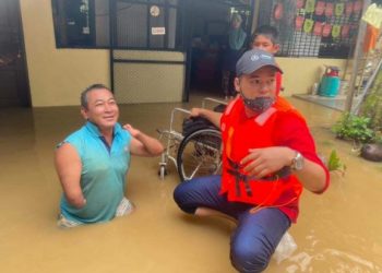 MOHD. SHUKRI bersama Mohd Khairi, salah seorang mangsa banjir.