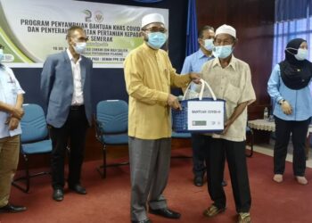PENANAM sayur, Latif Taib, 70, menerima bantuan diserahkan Dr. Nik Muhammad Zawawi di PPK Semerak, Pasir Puteh, Kelantan, hari ini.