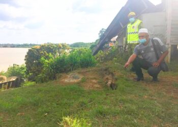 MOHAMMAD Azmi Mohammad Yusoff (duduk) bersama anggota Jabatan Sukarelawan Rakyat (Rela) menunjukkan rekahan tanah terbaru dikesan di Kampung Pohon Chelagi di sini hari ini.-UTUSAN/YATIMIN ABDULLAH