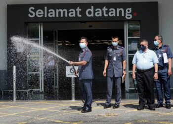 MOHAMAD Yusoff Abdul Rahman memeriksa gelong hos pemadam kebakaran di pasar raya Lotuss Ipoh, Bercham di Ipoh hari ini. -UTUSAN/ZULFACHRI ZULKIFLI