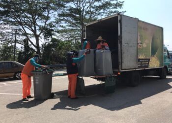 KAKITANGAN SWM Environemnt mengangkat tong sampah ke dalam lori untuk menggantikan kemudahan itu yang rosak atau hanyut akibat banjir di Johor Bahru, Johor.