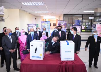 WAN Rosdy Wan Ismail (tengah) melihat kotak mengandungi dos vaksin keluaran Pfizer yang tiba di HTAA di Kuantan, Pahang hari ini.