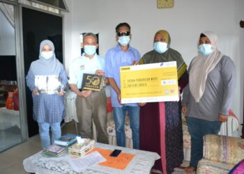 FUAD Alias (dua dari kiri) menyerahkan faedah Perkeso kepada Abdul Aziz (tengah) dan Razmah (dua dari kanan) di Taman Panchor Jaya, Seremban hari ini.-UTUSAN/ZAKKINA WATI AHMAD TARMIZI.