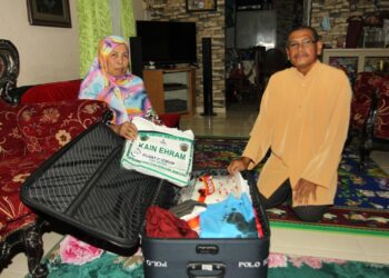 ABDUL Wahab Attan bersama isterinya menunjukkan beg persiapan untuk dibawa menunaikan haji di 
kediaman mereka di Kampung Melayu Majidee, Johor Bahru.